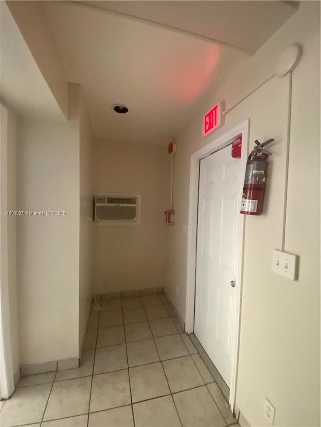 hall featuring light tile patterned floors and a wall unit AC