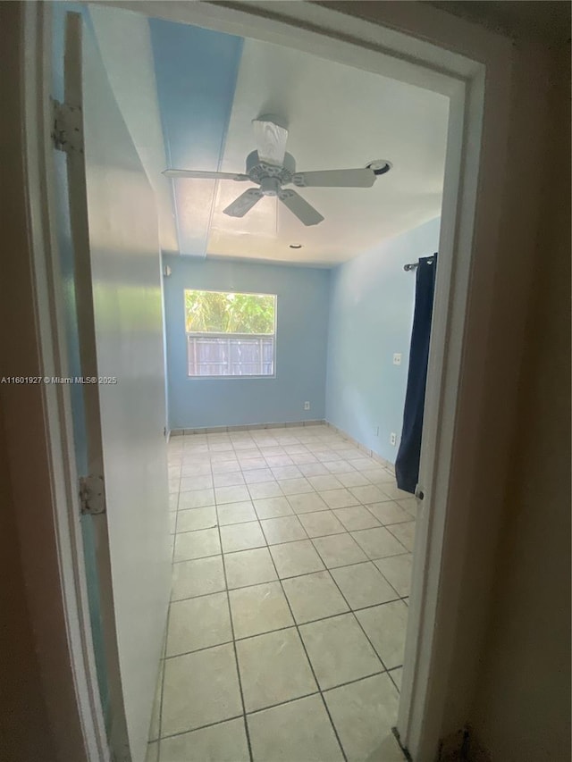 spare room featuring a ceiling fan and light tile patterned floors