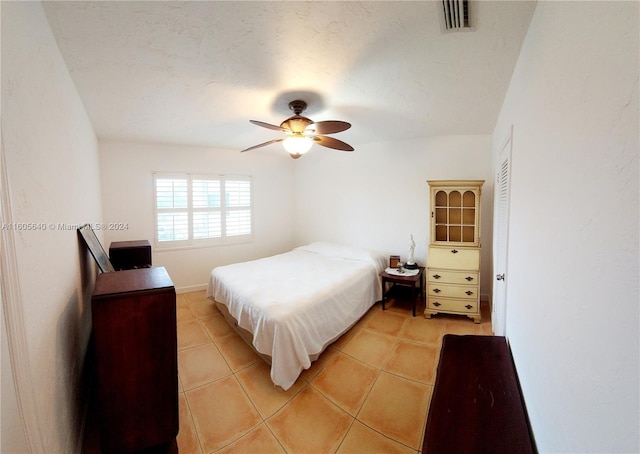 bedroom with tile flooring, ceiling fan, and a closet