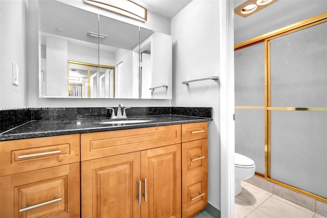 bathroom featuring vanity, an enclosed shower, and toilet