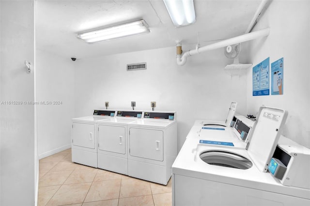 washroom with independent washer and dryer and light tile patterned floors