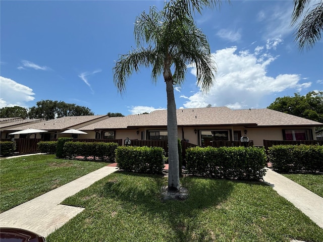 single story home featuring a front lawn