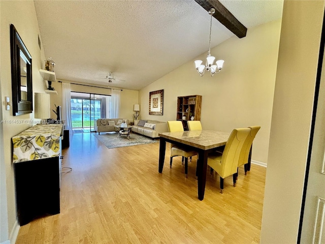 dining area featuring lofted ceiling with beams, ceiling fan with notable chandelier, a textured ceiling, and light hardwood / wood-style floors