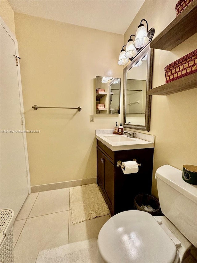 bathroom featuring toilet, vanity, and tile patterned flooring