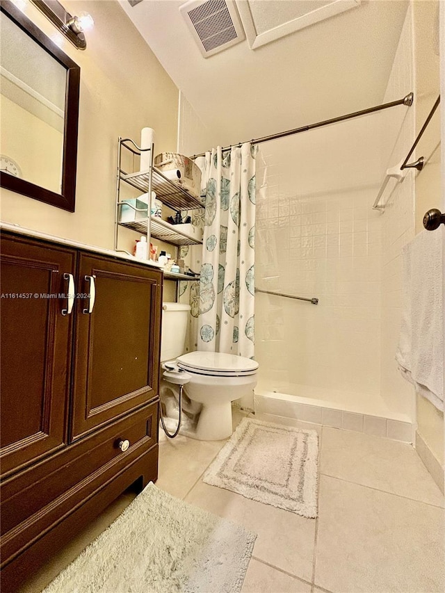 bathroom featuring toilet, a shower with curtain, and tile patterned flooring