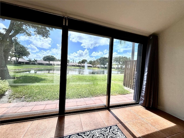 doorway with plenty of natural light, a water view, and tile patterned flooring