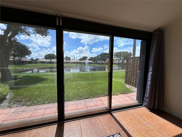 doorway to outside featuring tile patterned flooring, a water view, and plenty of natural light