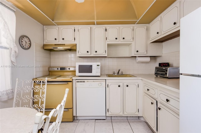 kitchen with white appliances, sink, white cabinets, and wall chimney exhaust hood