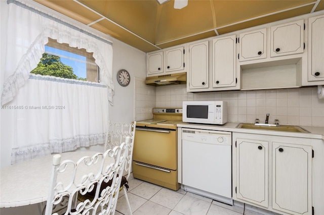 kitchen with white cabinets, light tile floors, white appliances, and backsplash