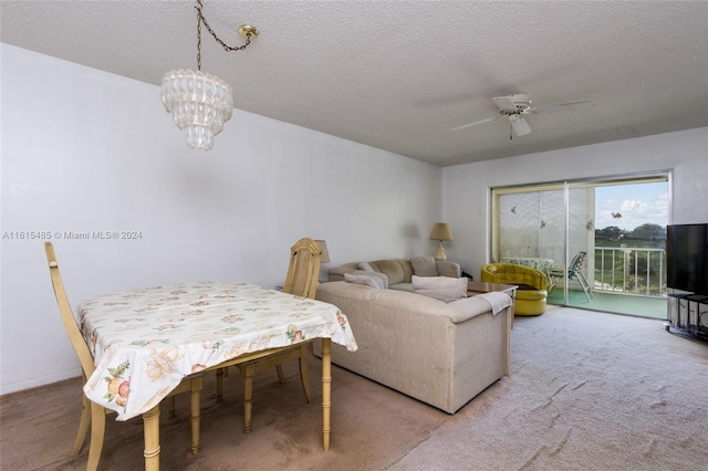 carpeted dining room featuring a textured ceiling and ceiling fan with notable chandelier