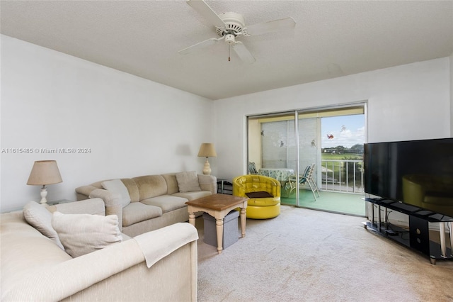 living room with carpet, ceiling fan, and a textured ceiling