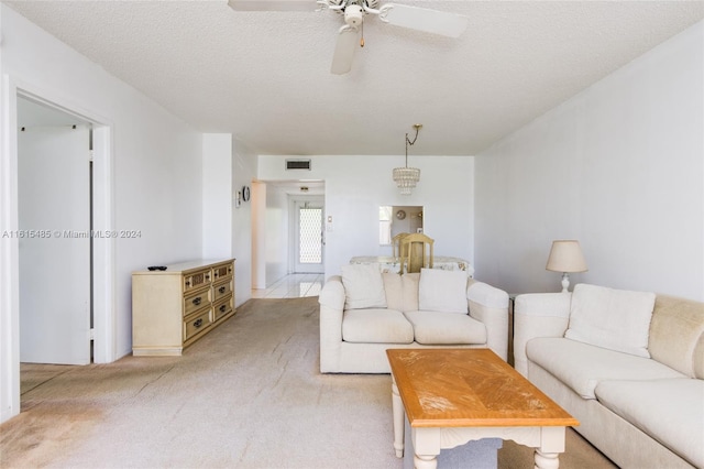 living room featuring carpet, ceiling fan, and a textured ceiling