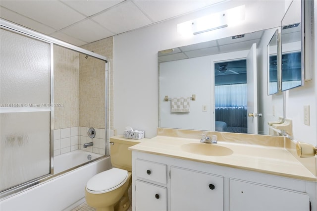 full bathroom featuring shower / bath combination with glass door, a paneled ceiling, toilet, and vanity