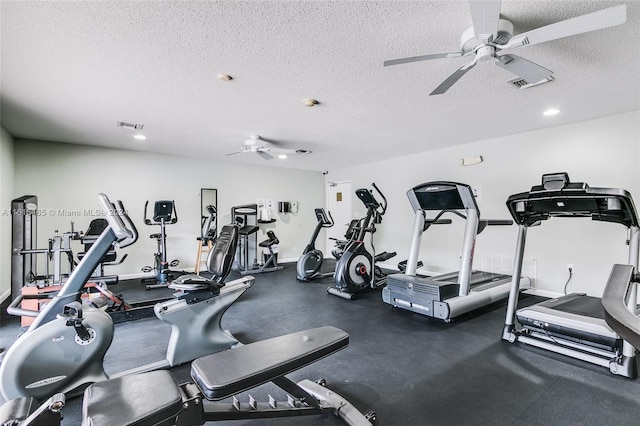 gym featuring ceiling fan and a textured ceiling