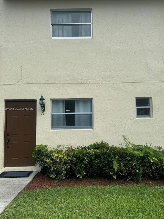 property entrance with a lawn