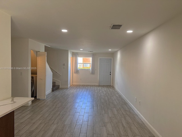 spare room with washer / dryer and light wood-type flooring