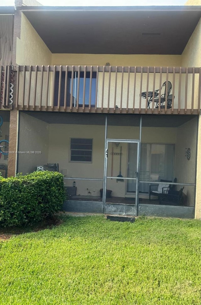 rear view of property with a yard and a sunroom