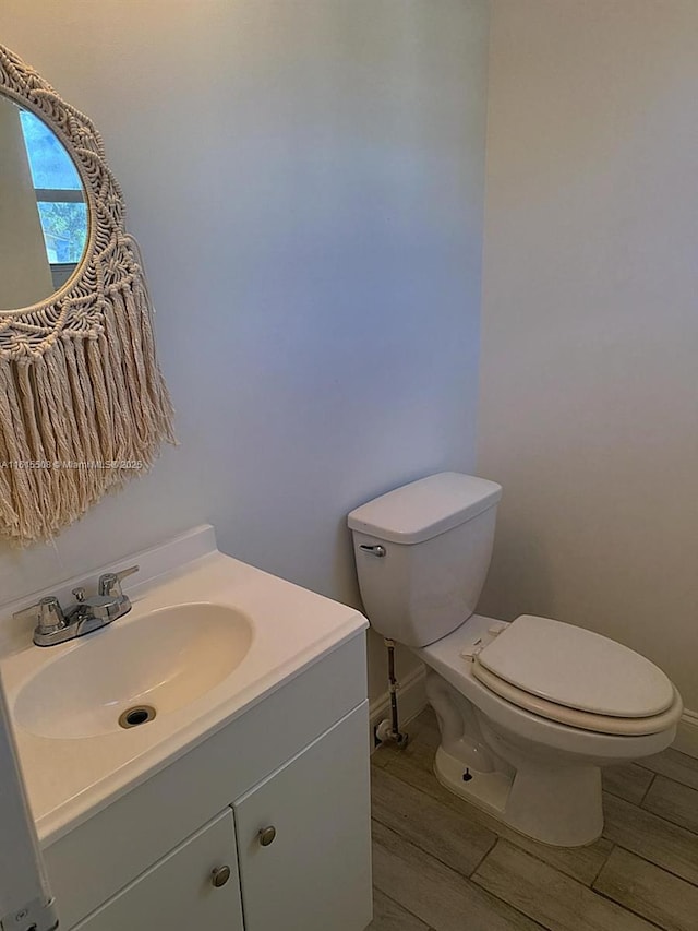 bathroom featuring vanity, hardwood / wood-style floors, and toilet