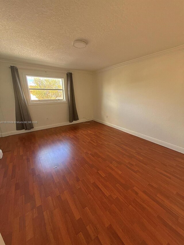 empty room featuring crown molding, dark hardwood / wood-style floors, and a textured ceiling