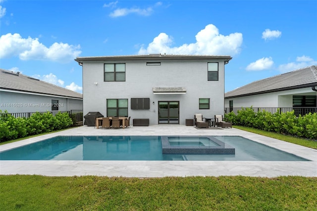 back of house with a swimming pool with hot tub and a patio