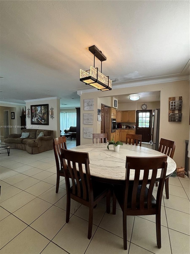 dining space featuring ornamental molding and light tile patterned floors