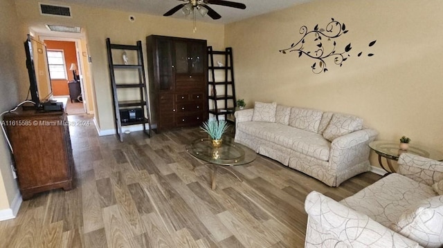 living room featuring ceiling fan and hardwood / wood-style flooring