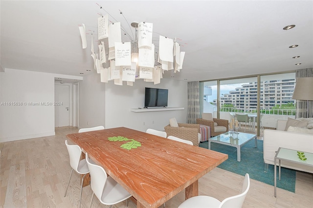 dining room featuring light wood-type flooring and a wall of windows