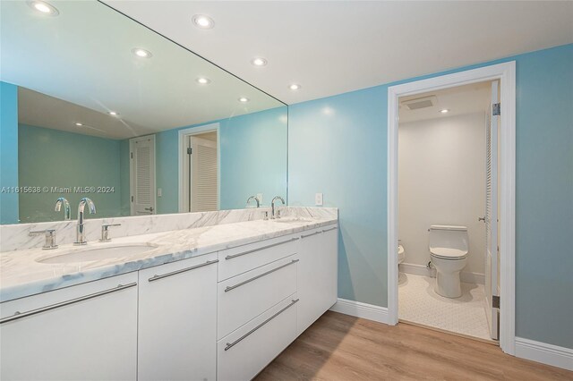 bathroom with dual vanity, hardwood / wood-style flooring, a bidet, and toilet