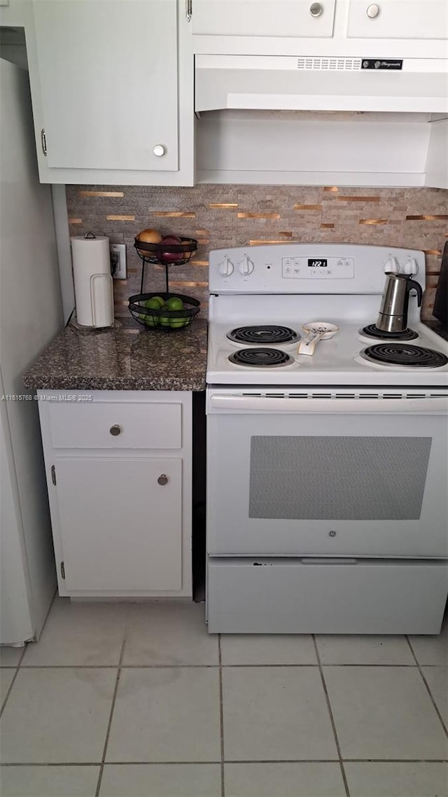 kitchen featuring white cabinetry, stainless steel refrigerator, light tile patterned floors, and electric range