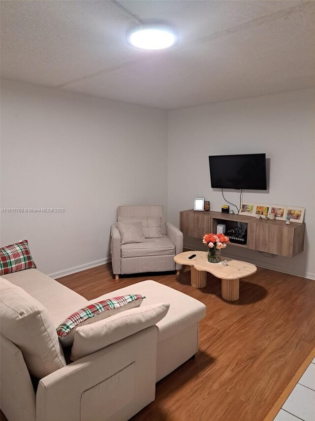 living room featuring ceiling fan, tile patterned flooring, and a textured ceiling