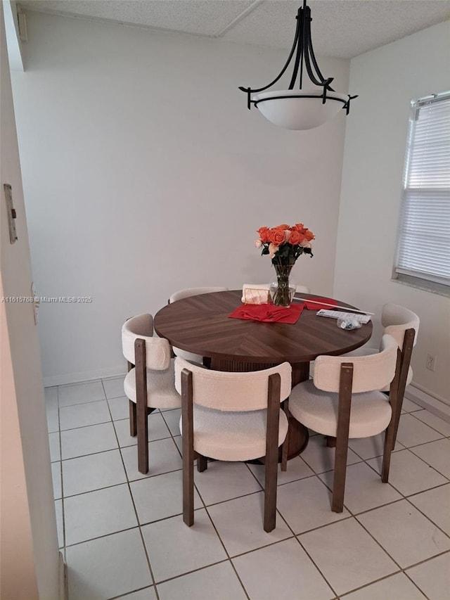 tiled dining space featuring a textured ceiling