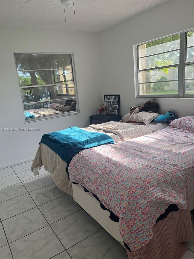 bedroom featuring light tile patterned flooring and a textured ceiling