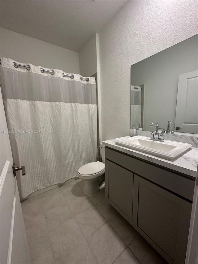 bathroom featuring a shower with curtain, toilet, vanity, and tile patterned flooring