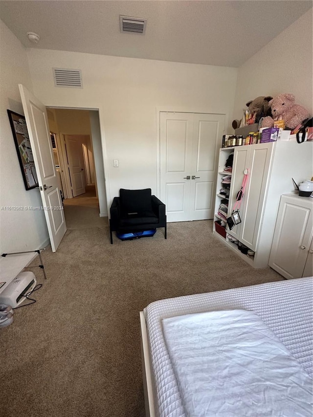 carpeted bedroom with a closet and visible vents