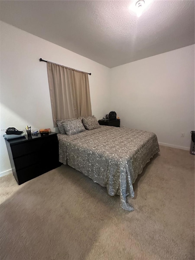 carpeted bedroom with baseboards and a textured ceiling