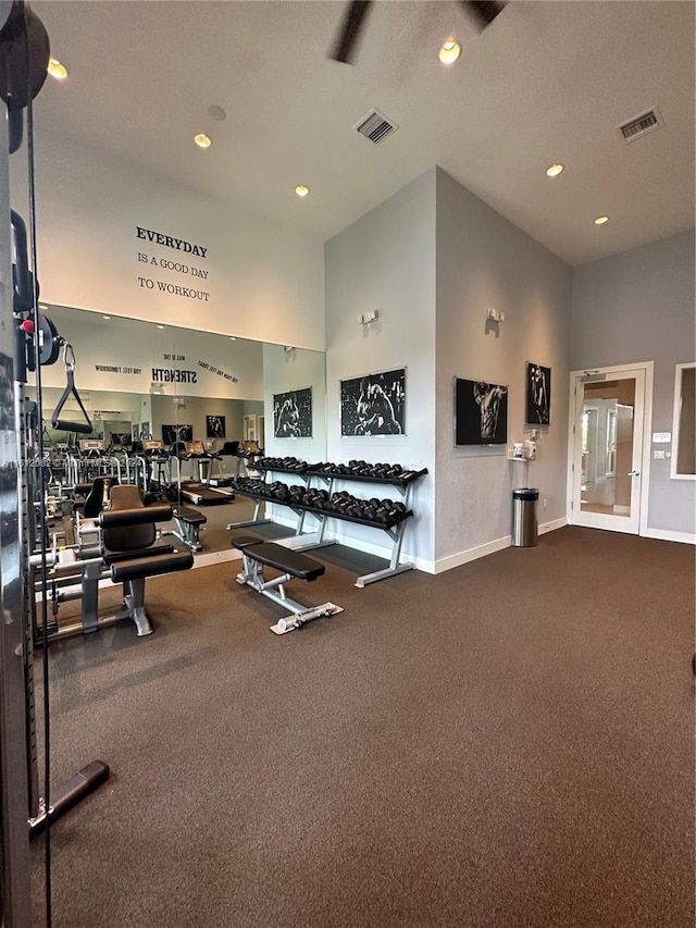 workout area featuring recessed lighting, visible vents, baseboards, and a high ceiling