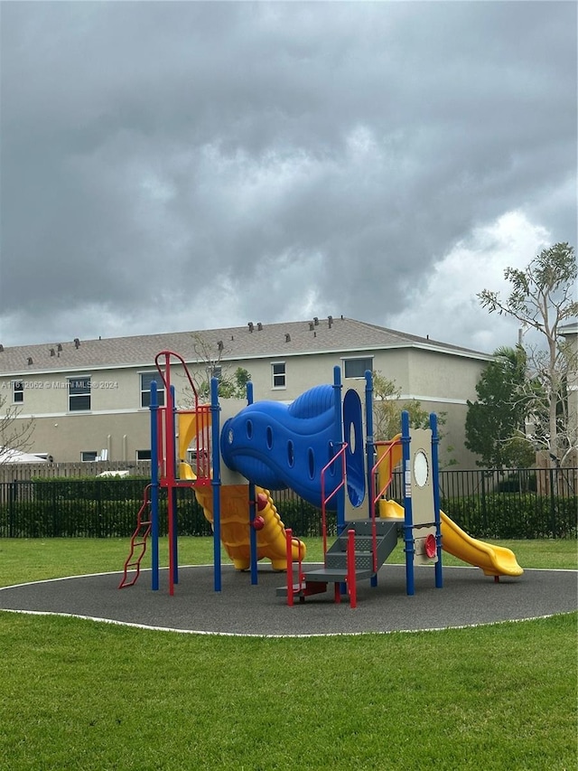 community play area featuring a yard and fence