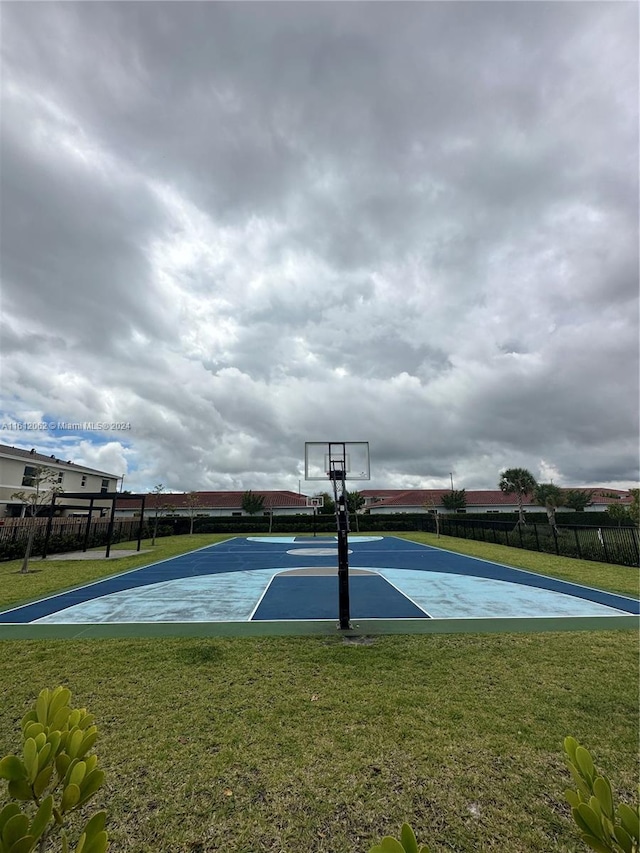 view of basketball court featuring community basketball court, a yard, and fence