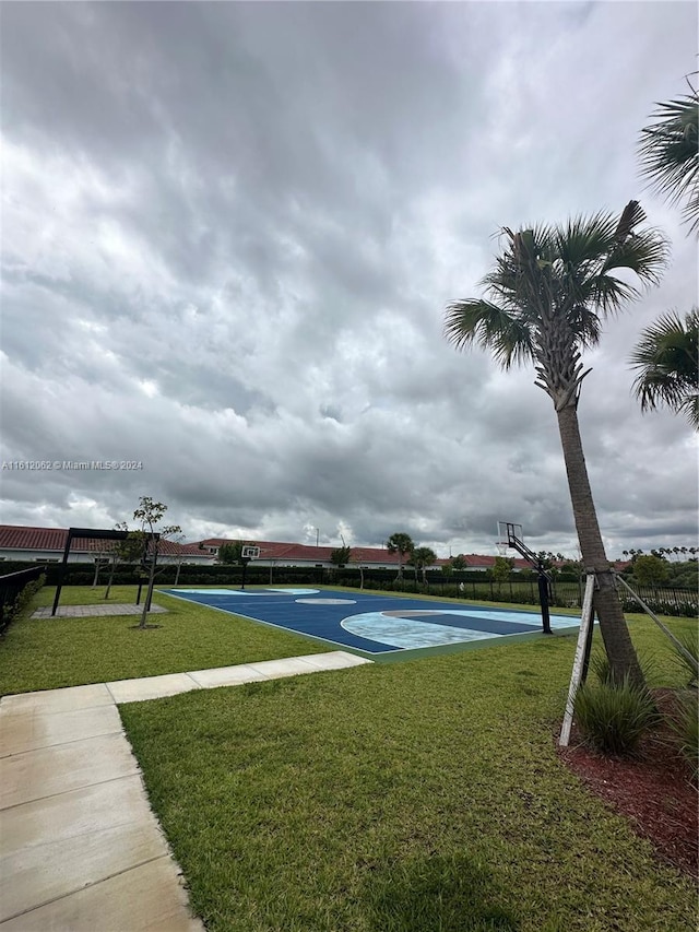 surrounding community with a yard, community basketball court, and fence