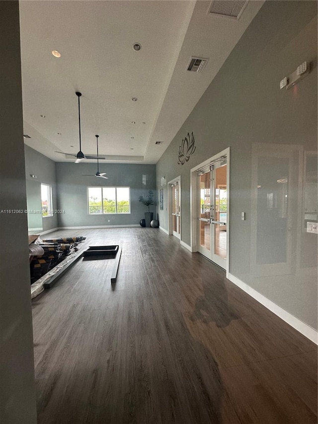 workout room featuring wood finished floors, visible vents, french doors, and baseboards