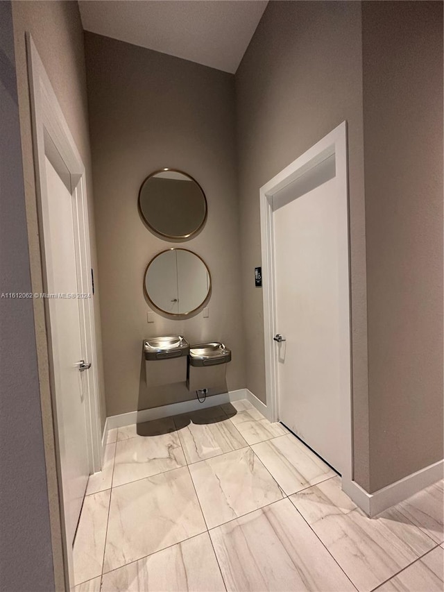 bathroom with baseboards and marble finish floor