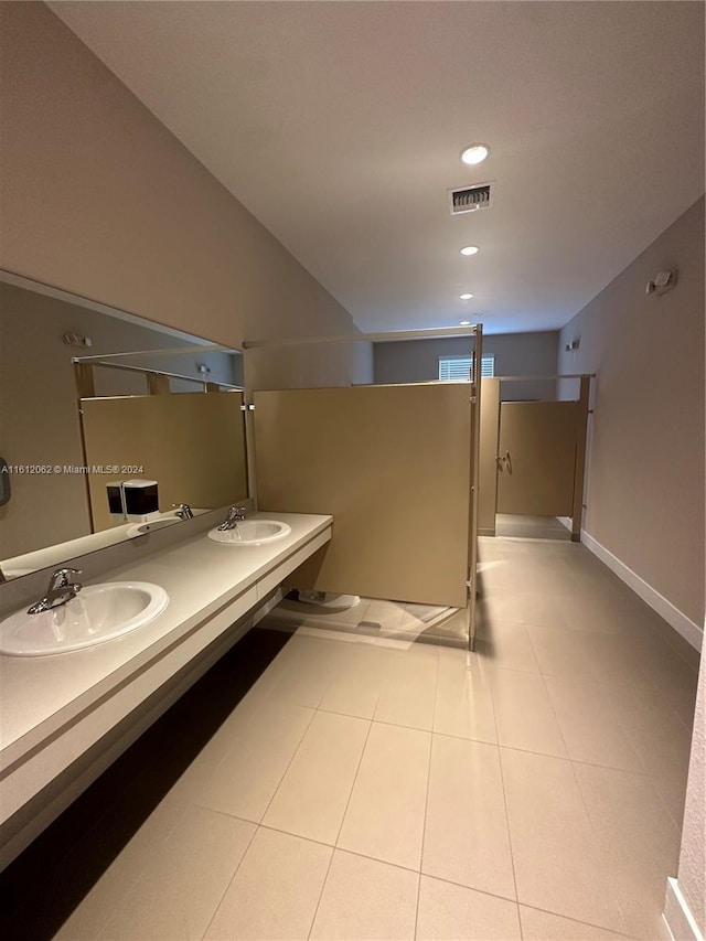 full bathroom featuring a sink, visible vents, double vanity, and tile patterned flooring