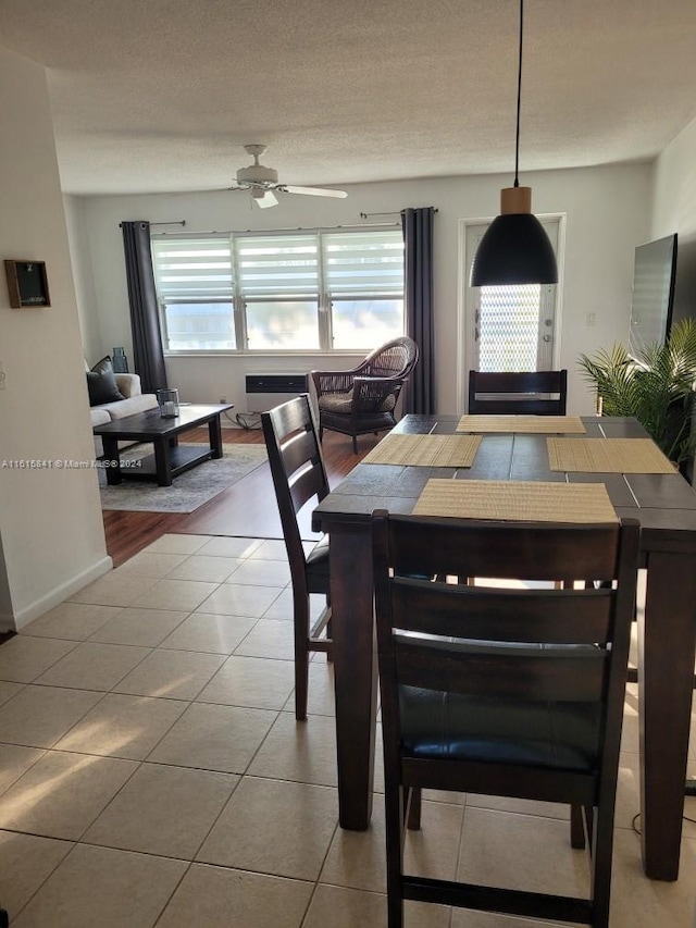 dining space featuring ceiling fan, light tile patterned floors, and a textured ceiling