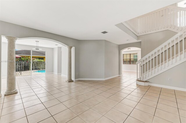 tiled empty room featuring decorative columns