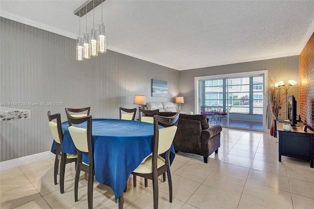 tiled dining area featuring ornamental molding, a textured ceiling, and a chandelier