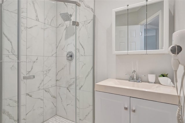 bathroom featuring a shower with door and vanity