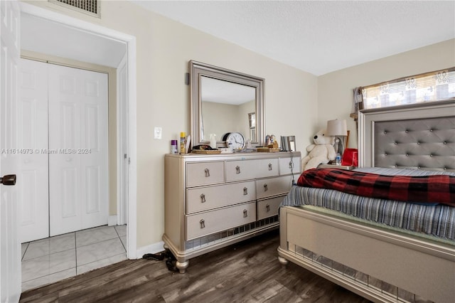 bedroom with hardwood / wood-style flooring, a textured ceiling, and a closet