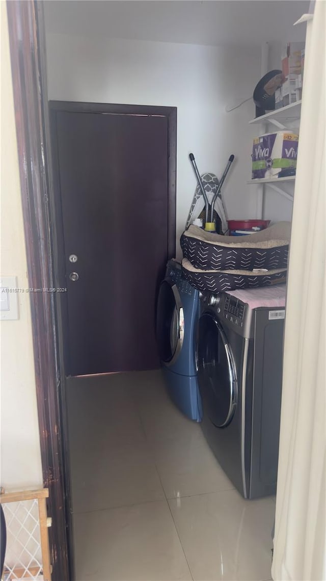 laundry room featuring washer and clothes dryer and tile patterned flooring