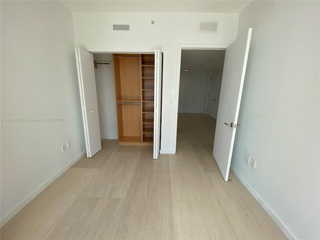 unfurnished bedroom with light hardwood / wood-style floors and a closet