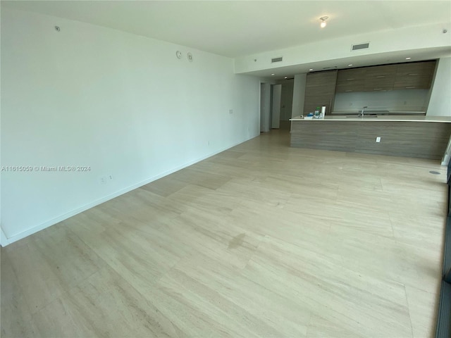 unfurnished living room featuring sink